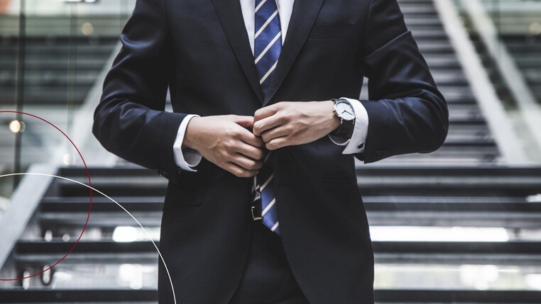 Mann knöpft sein Sakko zu