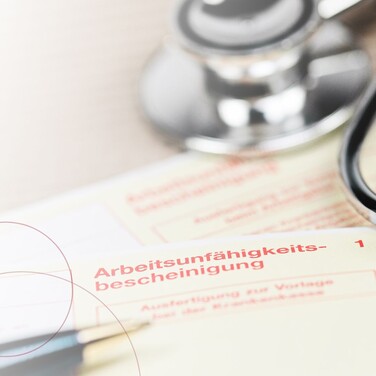 Ein Kugelschreiber liegt auf einem gelben Schein