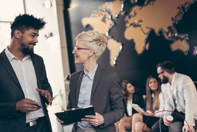 Eine Frau und ein Mann befinden sich bei der Arbeit in einem Gespräch.