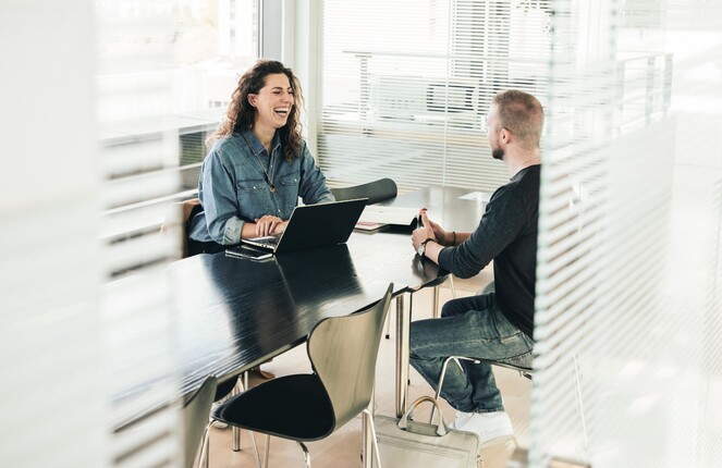 Rechteckiges Bild von zwei ttplern die in einem Meeting sitzen