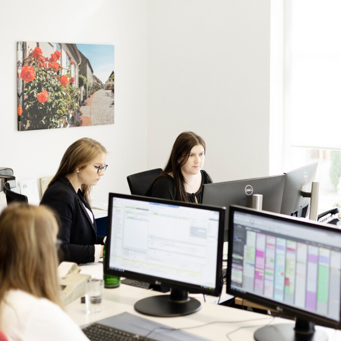 Drei ttp Mitarbeiterinnen sitzen am Computer