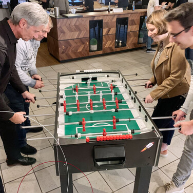 Vier ttpler spielen Tischkicker gegeneinander