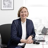 Kollegin Inga Bauch sitzt an ihrem Schreibtisch.