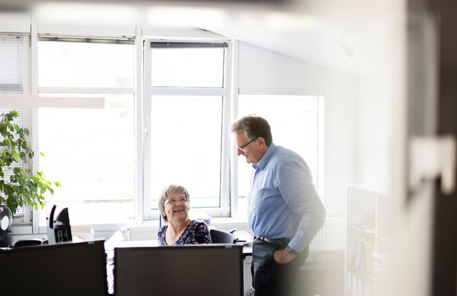 Zwei ttp Mitarbeiter unterhalten sich im Büro