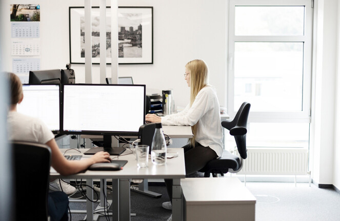 Eine ttp Mitarbeiterin trägt eine weiße Bluse