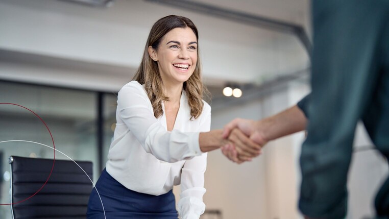 Eine Frau begrüßt ihren Mandanten.
