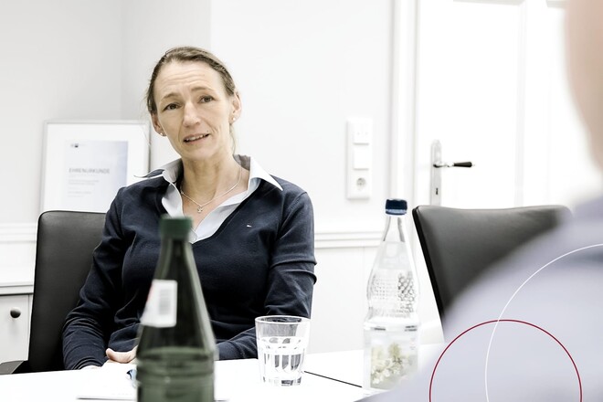 Beate Theede im Gespräch an einem Konferenztisch