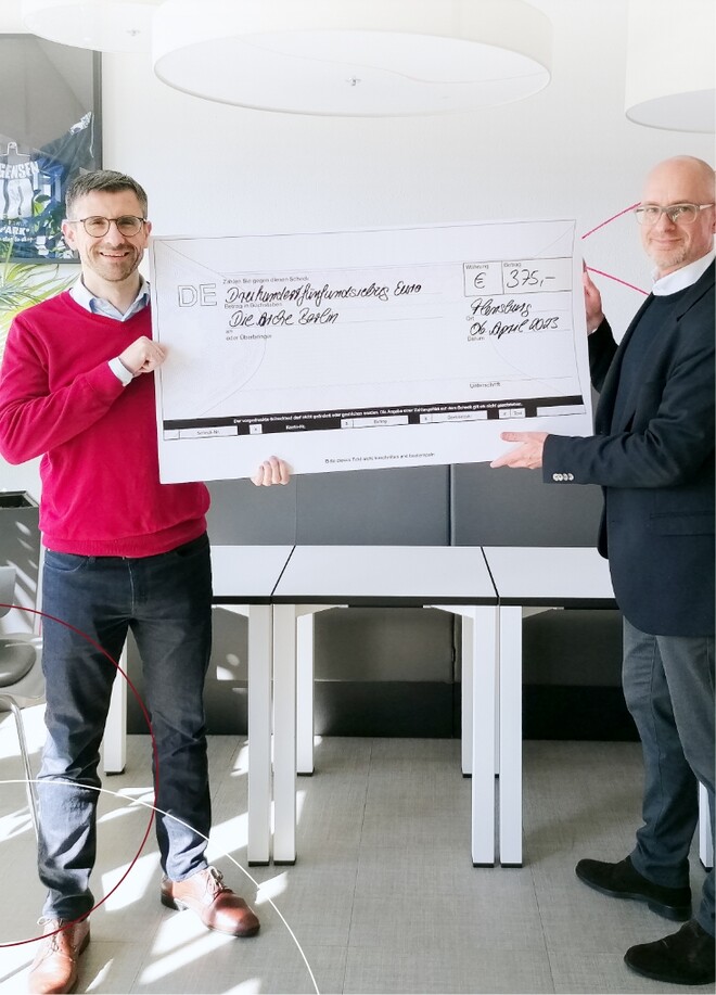 2 Männer mit Scheck in den Händen