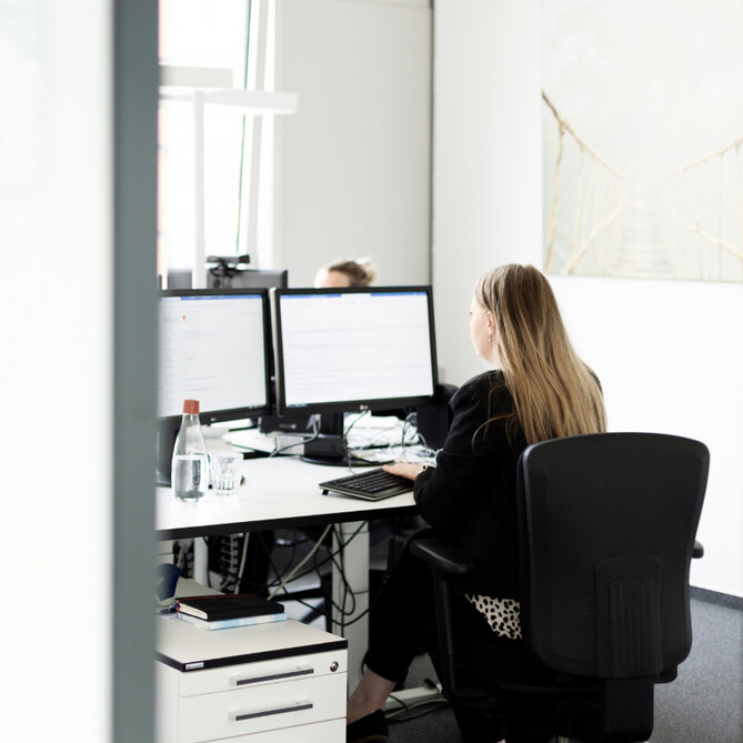 Eine brünette ttplerin sitzt im Büro
