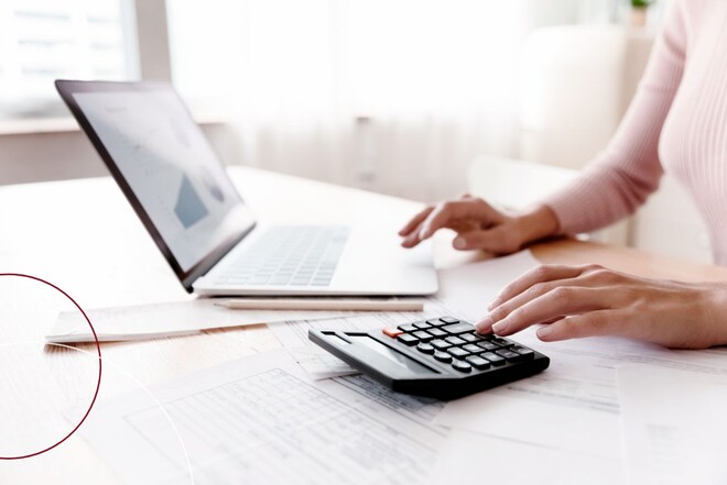 Eine Frau rechnet mit einem schwarzen Taschenrechner