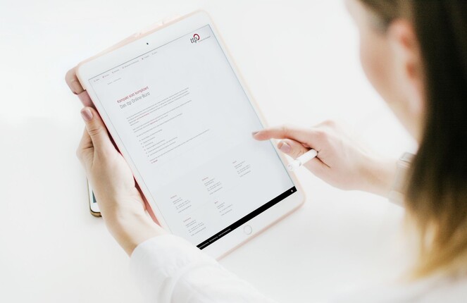 Ein rechteckiges Bild von einer Frau die auf einem Ipad tippt