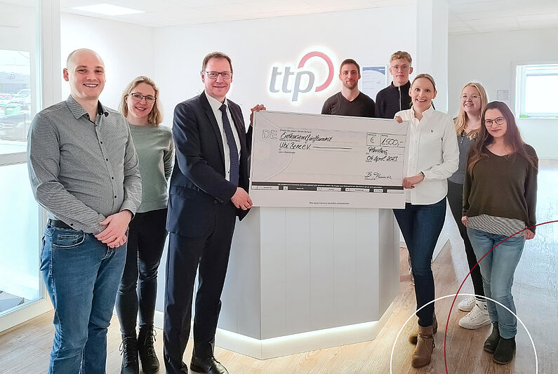 8 Personen mit Scheck in den Händen