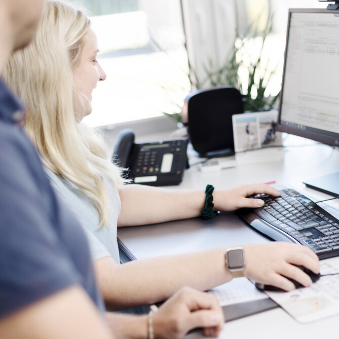 Zwei ttp Mitarbeiter arbeiten zusammen am Computer