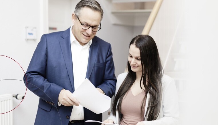 Zwei Kollegen sprechen über Unterlagen.