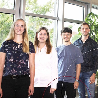 Vier Azubis posieren vor der Kamera