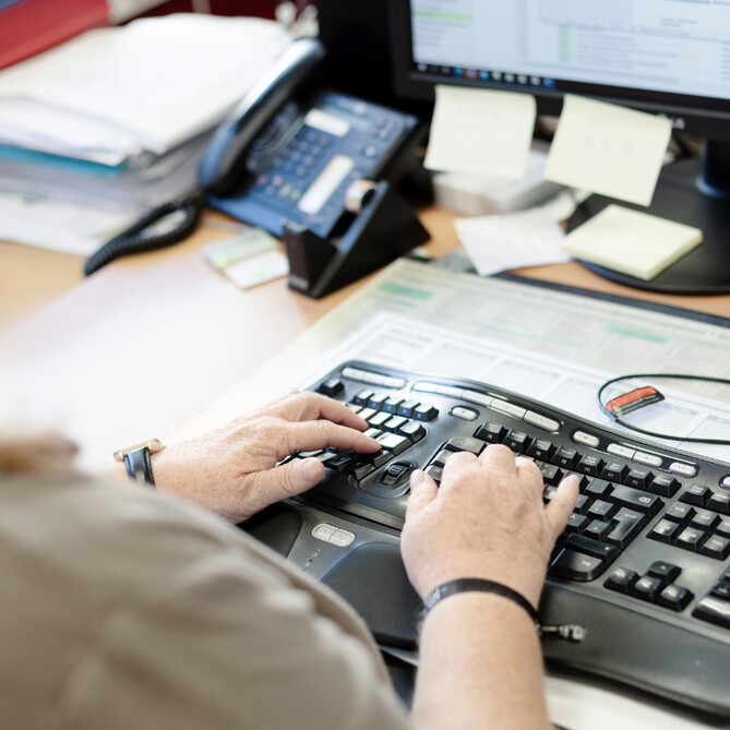 Eine Frau sitzt an einer schwarzen Tastatur