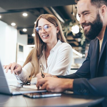 Kollegen sitzen gemeinsam vor einem Laptop