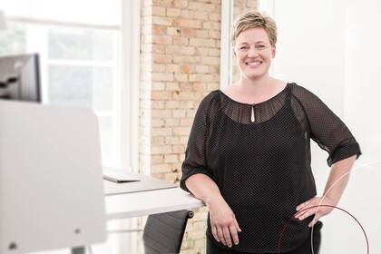 Manuela Versonke steht vor einem Schreibtisch