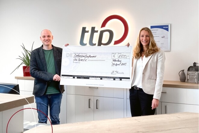 2 Personen mit Scheck in den Händen