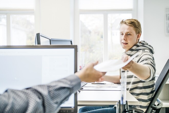 Kollege reicht einem anderen Papiere