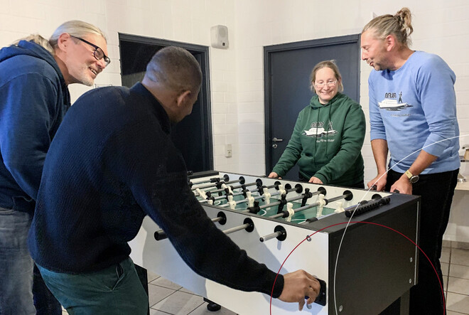 Vier ttpler stehen am Tischkicker