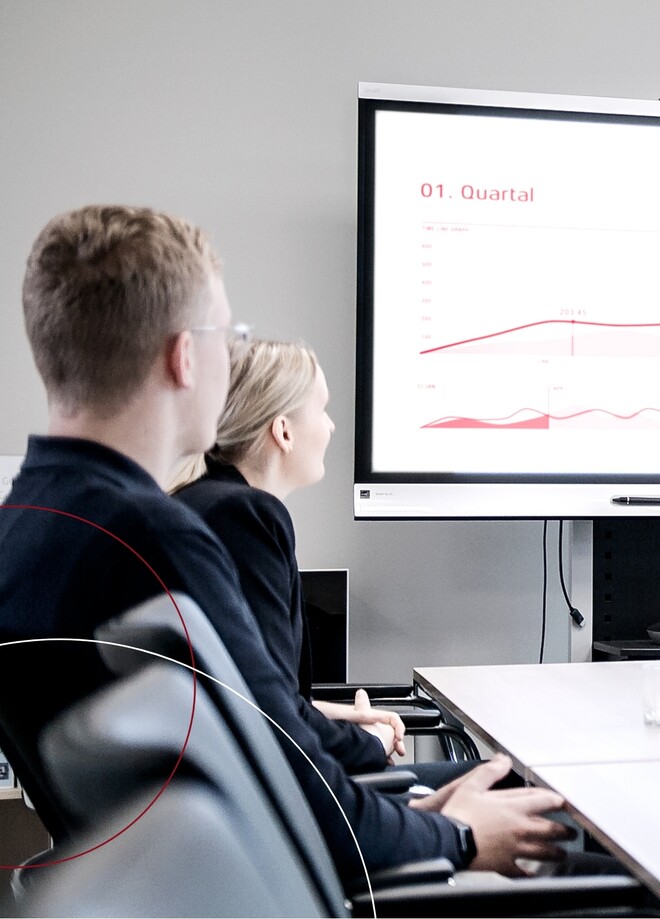 Zwei ttp Mitarbeiter hören einer Präsentation zu