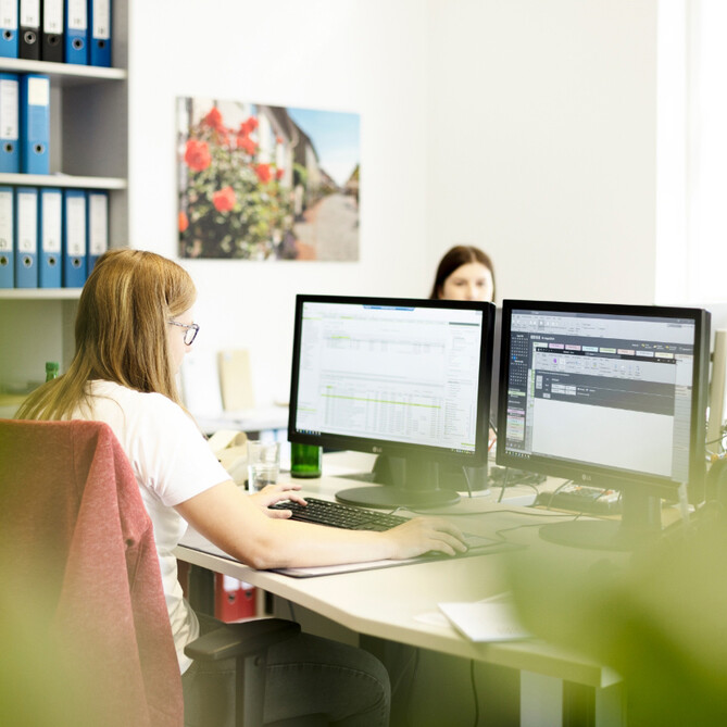 Eine junge ttp Mitarbeiterin arbeitet am PC