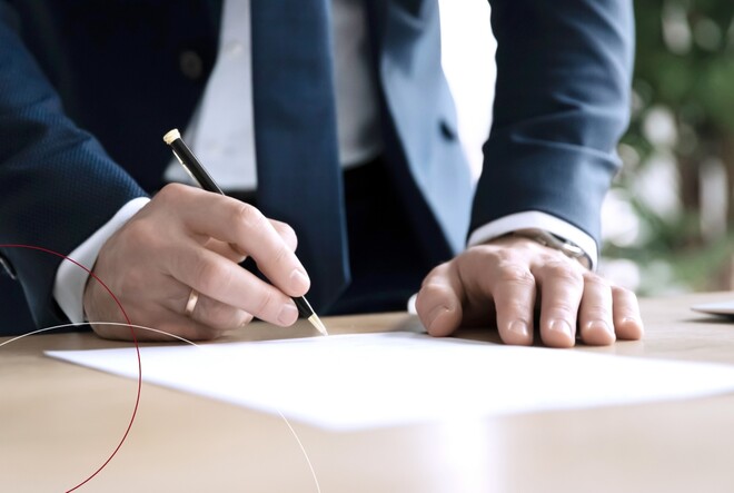 Ein Mann unterzeichnet ein Papier