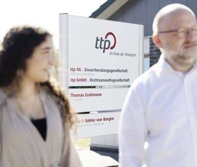 Rechteckiges Bild von zwei ttplern vor einem ttp Standort