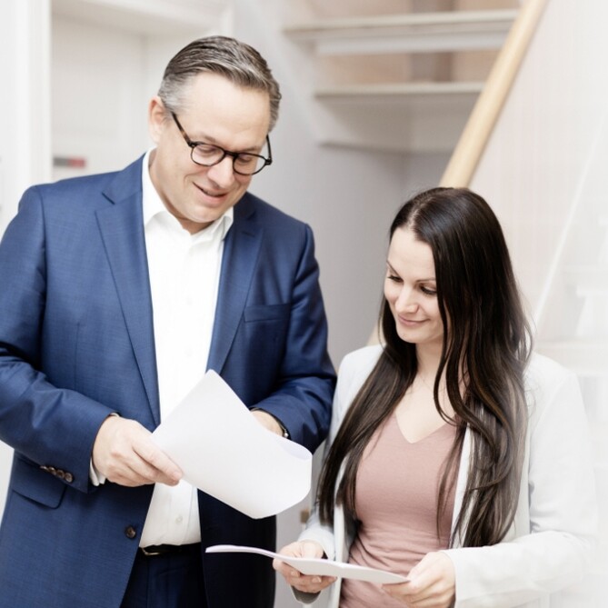 Ein ttpler zeigt auf ein Dokument in Papierform