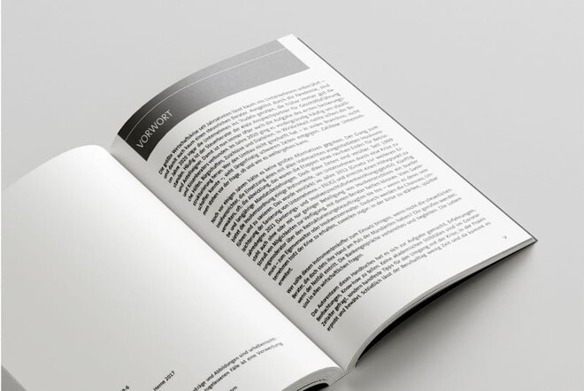 Aufgeschlagenes Buch vor grauem Hintergrund