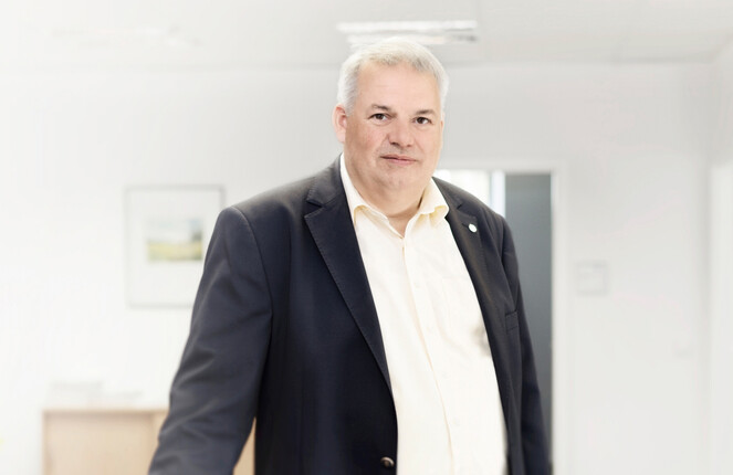 Ein ttpler steht mit Anzug im Büro