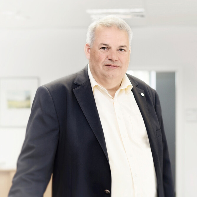 Ein ttpler steht mit Anzug im Büro