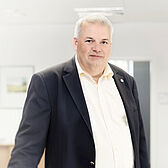 Ein ttpler steht mit Anzug im Büro