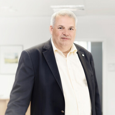 Ein ttpler steht mit Anzug im Büro