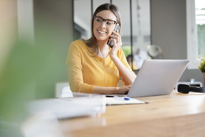 Eine ttplerin telefoniert am Laptop