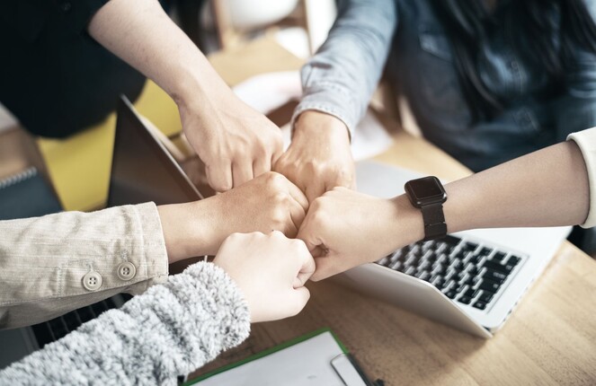 ttp Generationenberatung – Fäuste von unterschiedlich alten Menschen bilden einen Kreis