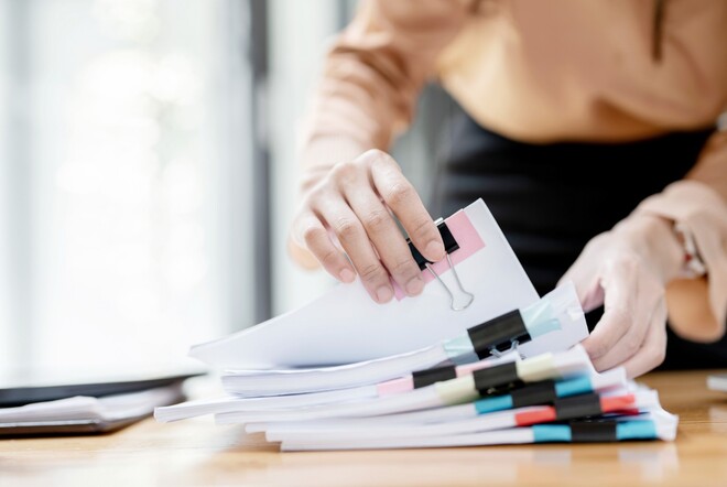 Eine Frau sortiert Unterlagen.