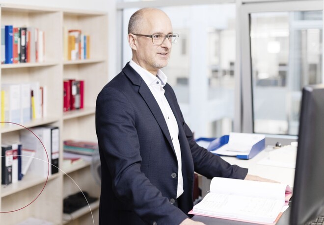 Thomas Bertram von ttp steht am Schreibtisch