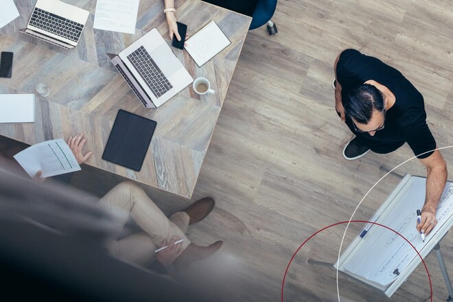 Mann schreibt etwas an ein Flipchart