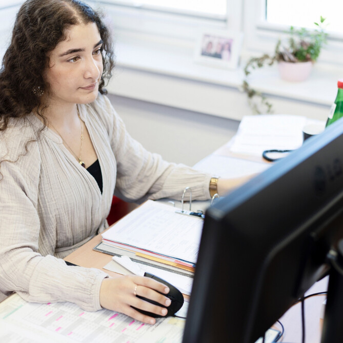 Eine ttp Mitarbeiterin arbeitet konzentriert am Computer