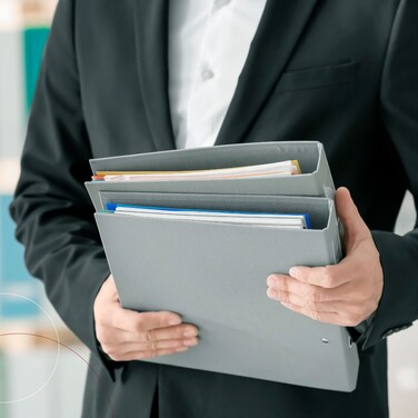 Ein Mann hält Ordner in der Hand