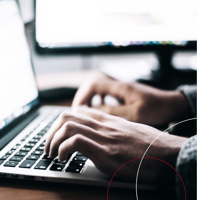 Eine Person tippt auf einem silbernen Macbook