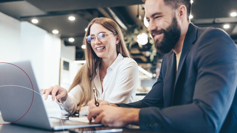 Kollegen sitzen gemeinsam vor einem Laptop