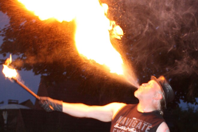 Ein Mann spuckt Feuer.