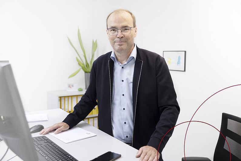 Frank Hansen steht an seinem Schreibtisch