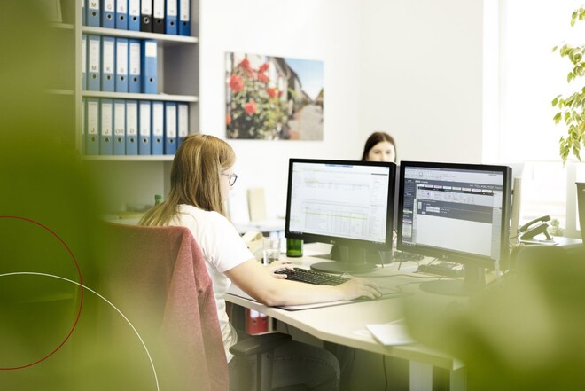 Blick ins Büro auf einen Arbeitsplatz mit zwei Bildschirmen