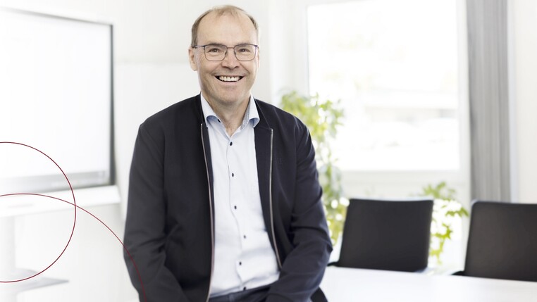 Frank Hansen sitzt auf einem Tisch