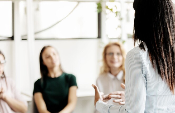 Rechteckiges Bild von einer Frau die einen Vortrag hält