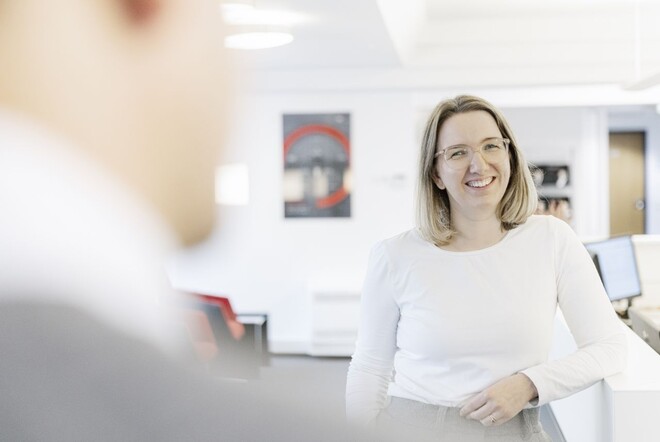 Eine Frau sitzt einem Mann in Büroräumen gegenüber.